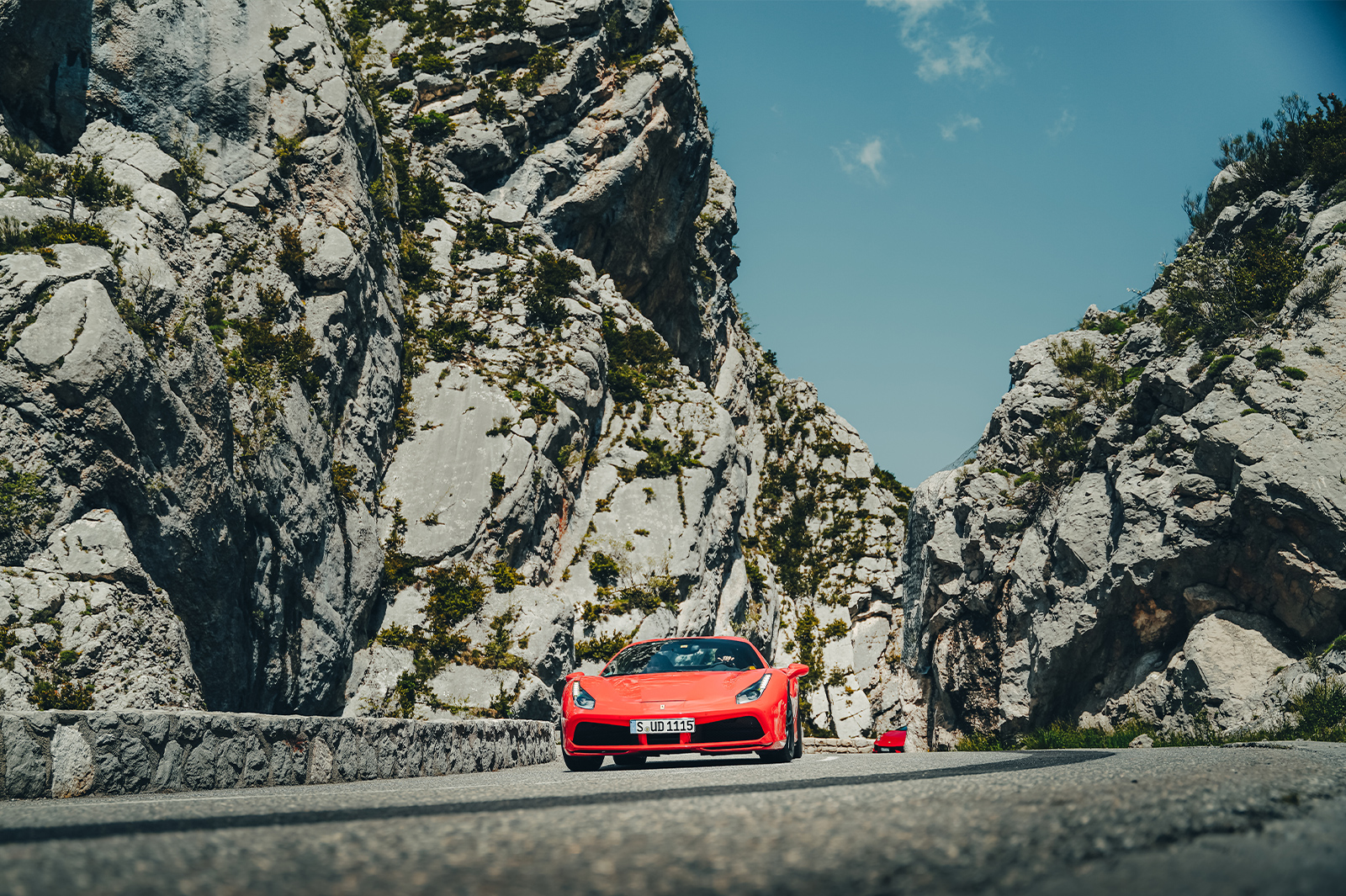 A red Ferrari carves through a steep rocky gully on an Ultimate Driving Tours holiday