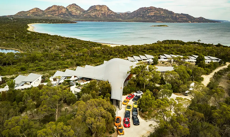 An aerial view of the Ultimate Driving Tours fleet of supercars at a stunning coastal resort in Australia