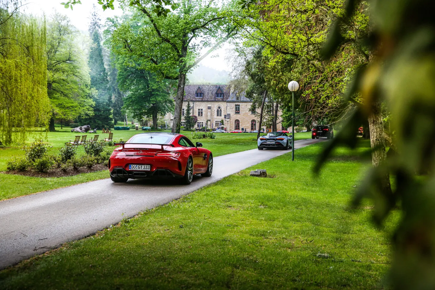 Mercedes and Mclaren driving down the driveway of five-star hotel in France