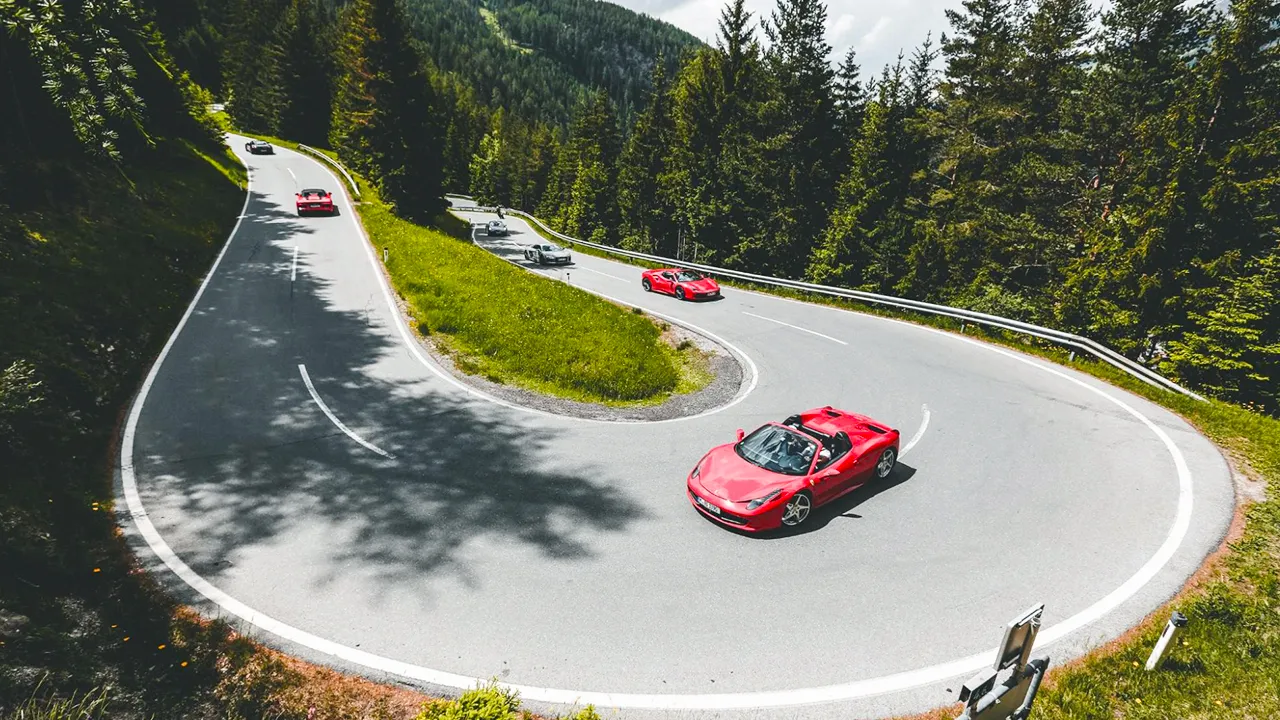 Red supercars tackling the twists and turns of San Bernardino Pass in Switzerland